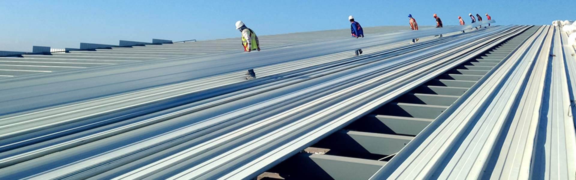 Trabajadores de la construcción instalando lámina KR-18 en un techo