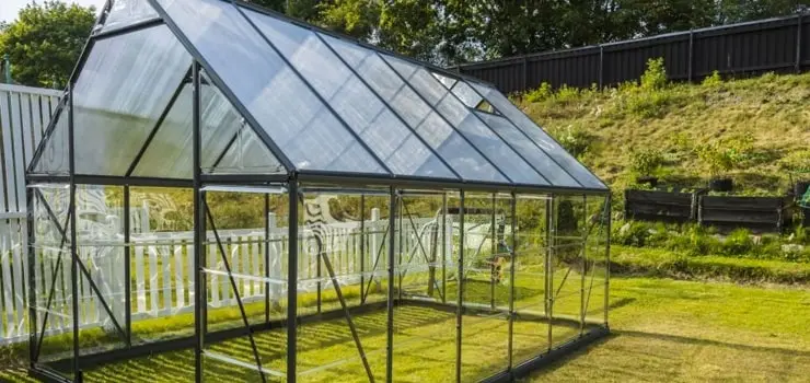 Patio trasero con techo de policarbonato transparente instalado sobre estructura metálica