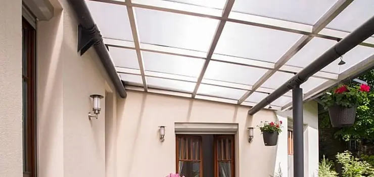 Terraza en de un departamento cubierta con un techo de policarbonato celular y piezas de acero