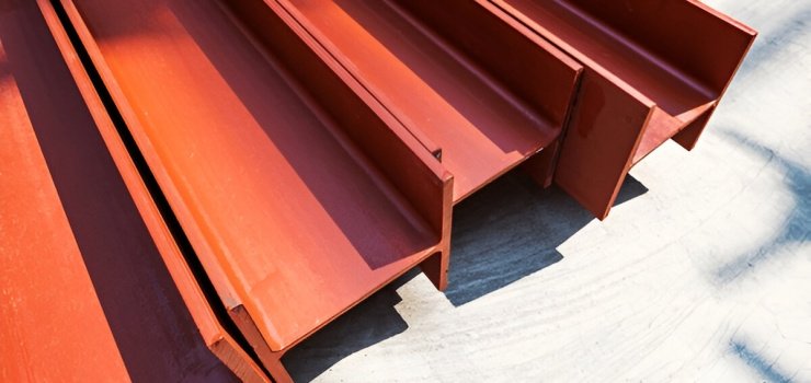 Cuatro vigas de acero pintadas de color rojizo