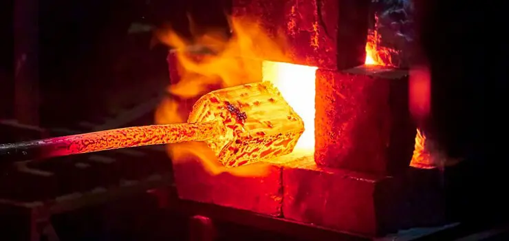 Fraguado de pieza metálica en horno de herrería