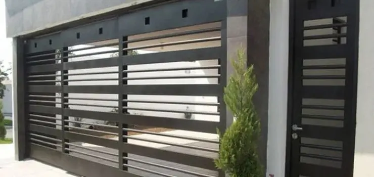 Portón negro de herrería hecho con soleras y perfiles redondos macizos