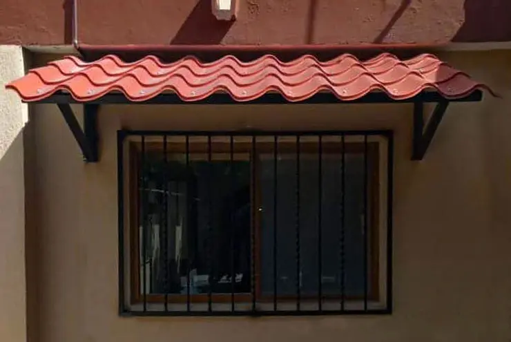 Protecciones para ventanas de herrería herrería con marquesinas de Galvateja sobre ellas