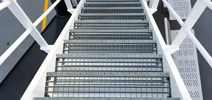 Escalera de herrería moderna recta, blanca y con escalones de rejilla electroforjada