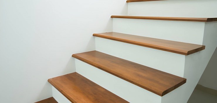 Tramo de escaleras de concreto color blanco revestidas con apoyos de madera