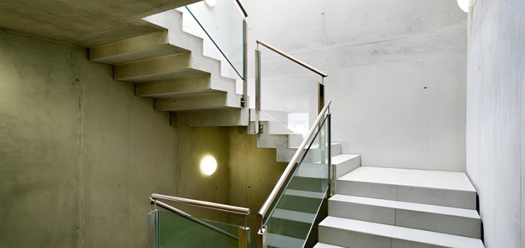 Escaleras de concreto con barandales de acero y vidrio