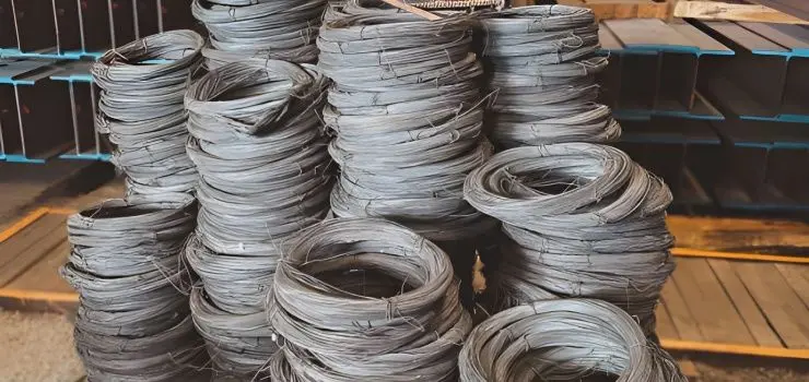 Rollos de alambre recocido apilados frente a vigas de acero en un almacén