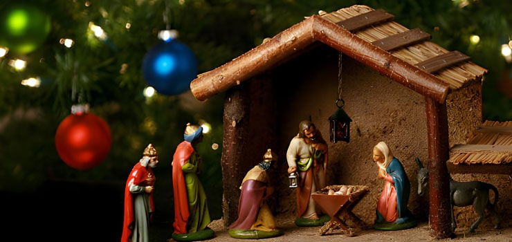 Figuras de nacimiento, pesebre y establo con árbol navideño de fondo - Adornos de Navidad