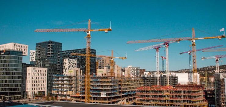 Conjunto de grúas construyendo edificios de gran magnitud - Industria de la construcción