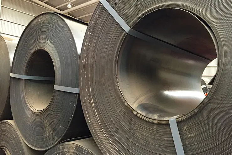 Rollos de acero al carbón apilados en una bodega - Aceros al carbono