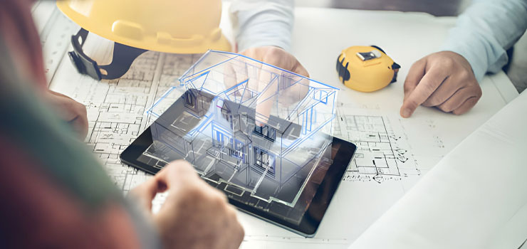 Arquitectos revisando en una tableta los planos para construir una casa