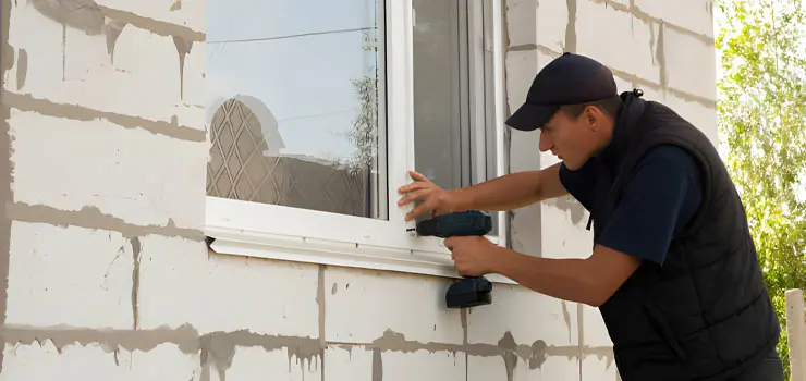 Hombre instalando ventana exterior al construir una casa