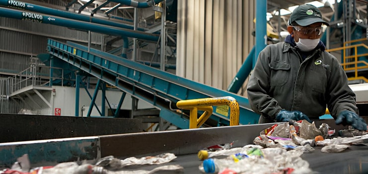Trabajador separando botellas de plástico dentro de una planta de reciclaje de pet