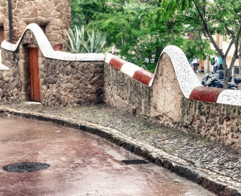 Barda de piedra con puerta de madera y decoración de cerámica