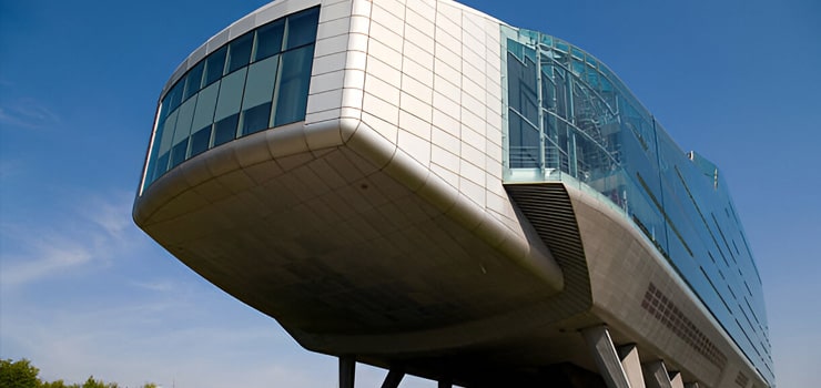 Edificio en forma de zeppelin con pilares y distintos ventanales - Arquitectura moderna