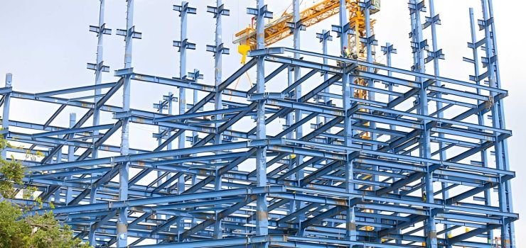 Estructuras metálicas entramadas de color azul y grúa de construcción amarilla