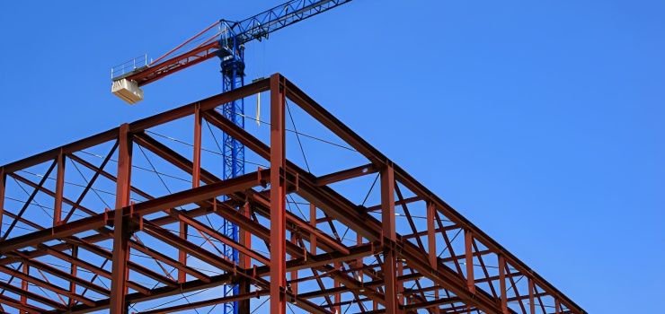 Estructura metálica de acero y grúa frente a cielo azul