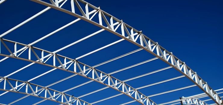 Estructuras metálicas con patrones triangulares, coloración blanca y configuración curva