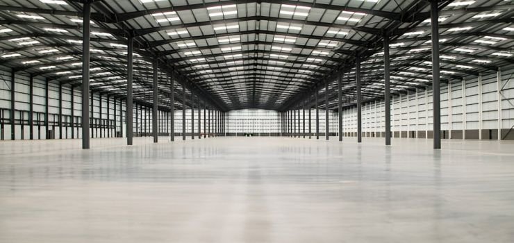 Interior de nave industrial amplia y vacía con estructura de acero color negro