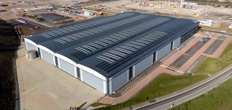 Toma aérea de cuatro grandes naves industriales en un parque industrial en construcción